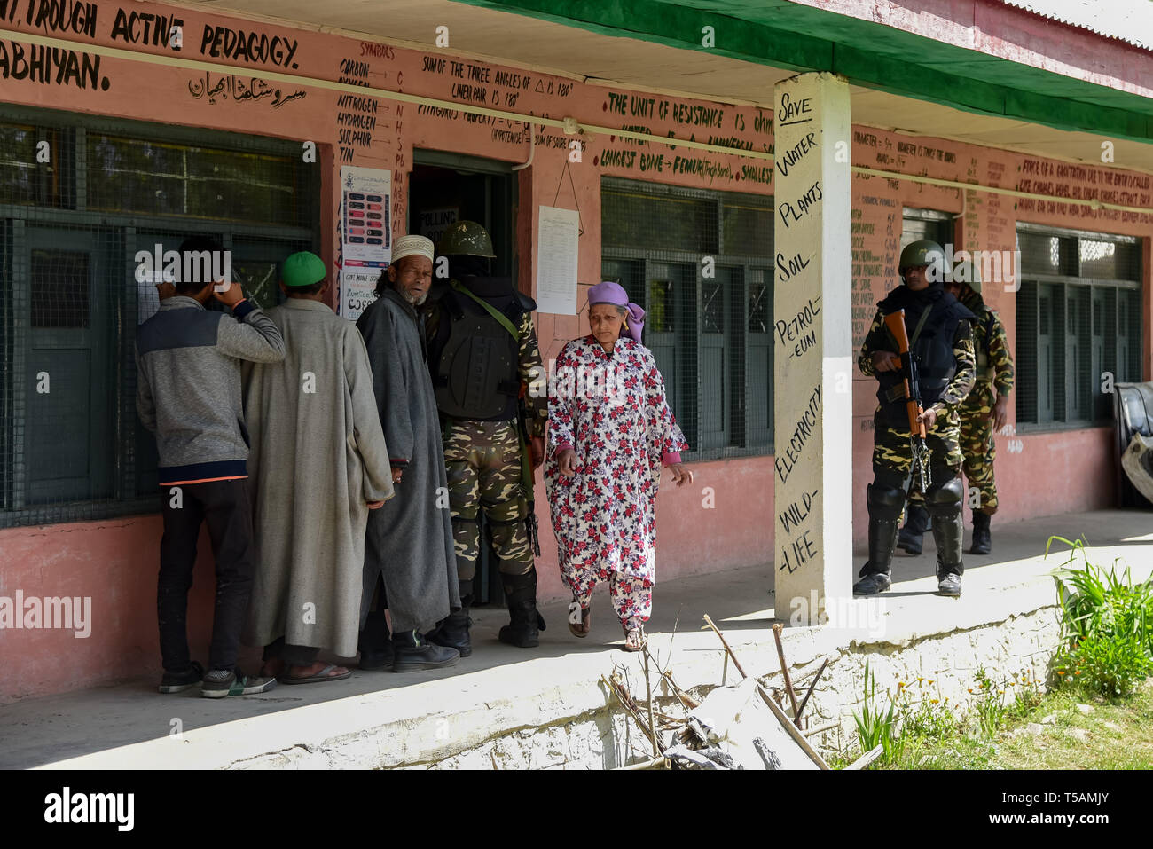 Die regierungstruppen gesehen stehen auf der Hut wie Kaschmir Wähler in einer Warteschlange stehen, ihre Stimmen vor einem Wahllokal in Anantnag, in Kaschmir zu werfen. In der dritten Phase der Parlamentswahlen in Indien Wahlen, Inder gingen nach Umfragen unter komplett heruntergefahren und internet Gag. Stockfoto