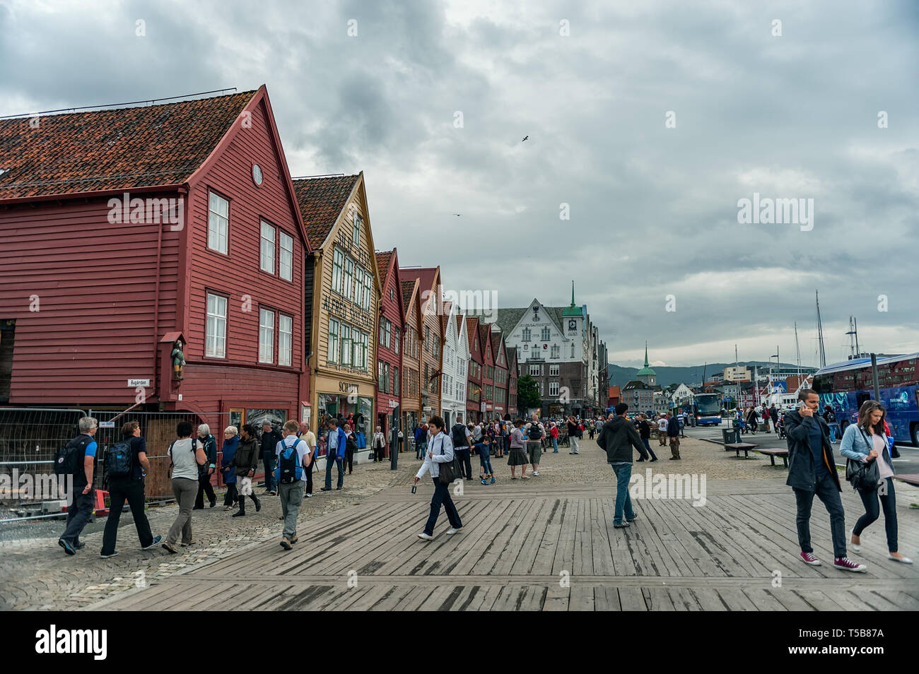 Bergen, Norway-July 30, 2013: Foto von der hölzernen Promenade von Bergen an einem bewölkten Tag. Leute Spaziergang entlang der Uferpromenade. Stockfoto