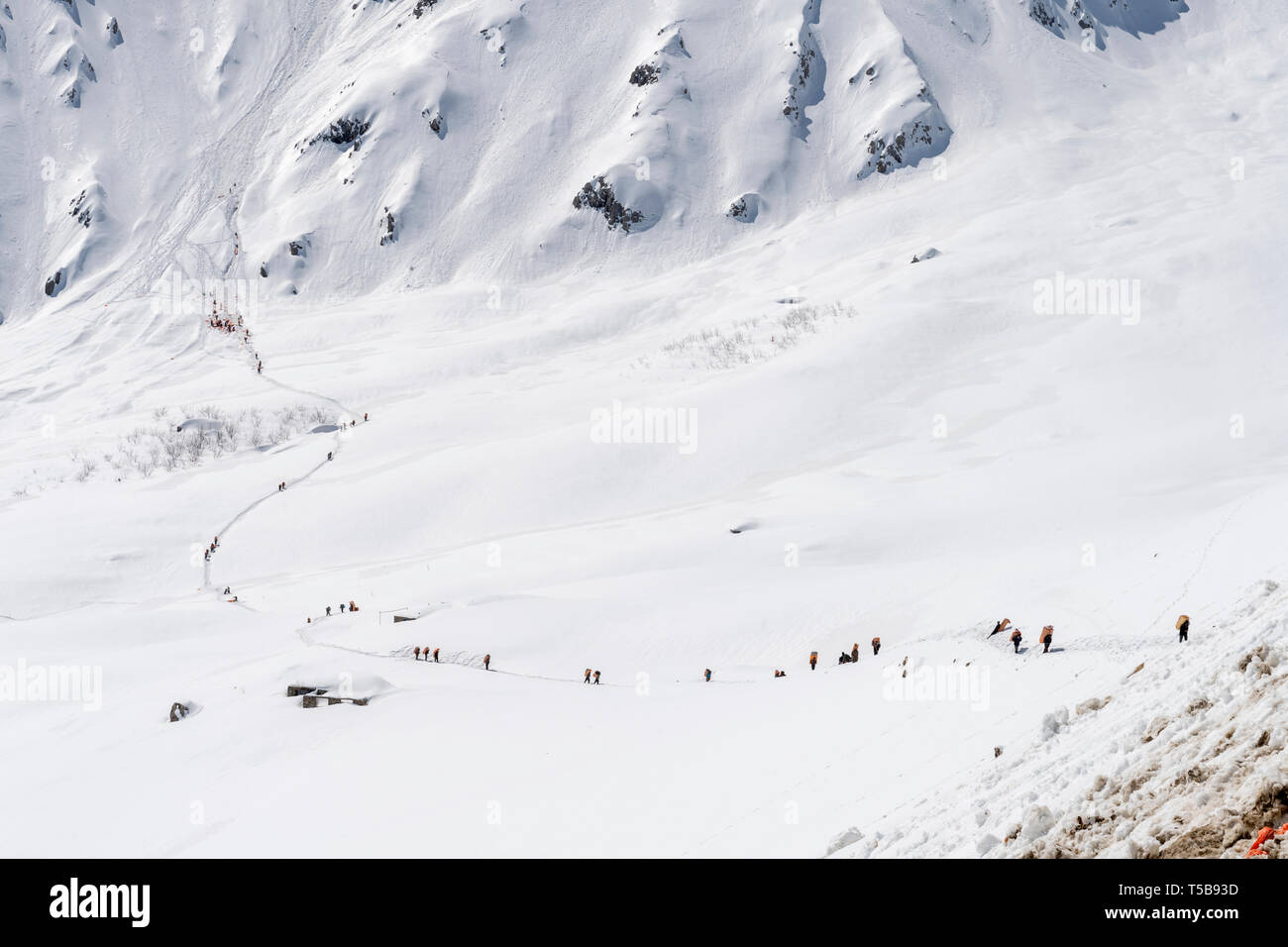 Kuriere Tragetaschen mit einem Gewicht bis zu 50 kg geschmuggelte Güter über Mountain Pass im Schnee im Winter im Tal Uraman, Provinz Kurdistan, Iran Stockfoto