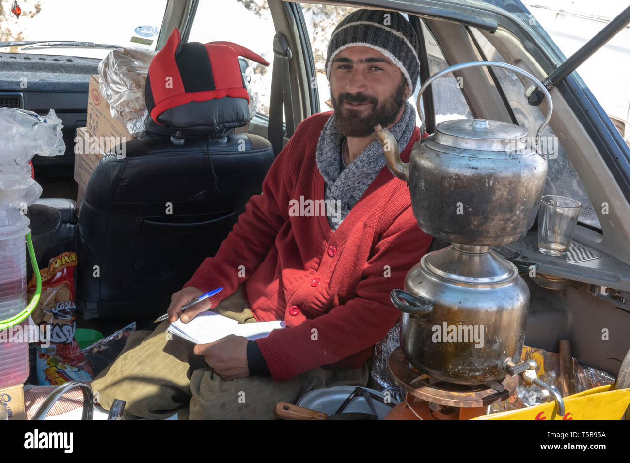 Schmuggler verkauft Kaffee im Auto im Winter am Straßenrand Basar in Uraman Tal, Provinz Kurdistan, Iran Stockfoto