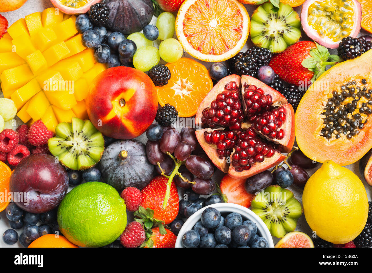 Leckere, gesunde Früchte Hintergrund mango papaya Erdbeeren Passionsfrüchte orangen Beeren, Ansicht von oben, selektiver Fokus Stockfoto