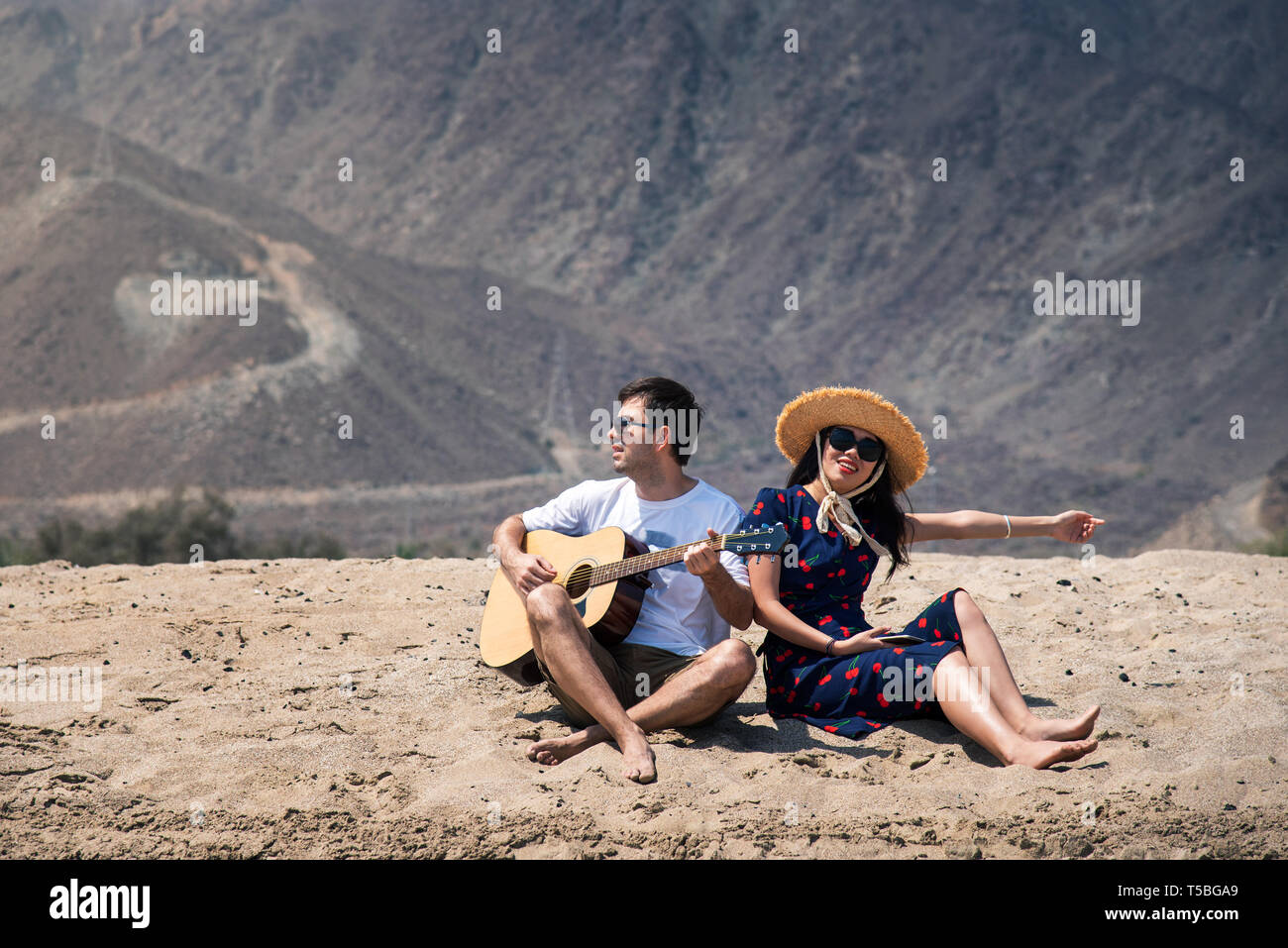 Paar singen und spielen Gitarre kaufen am Strand Sommer Urlaub Stockfoto