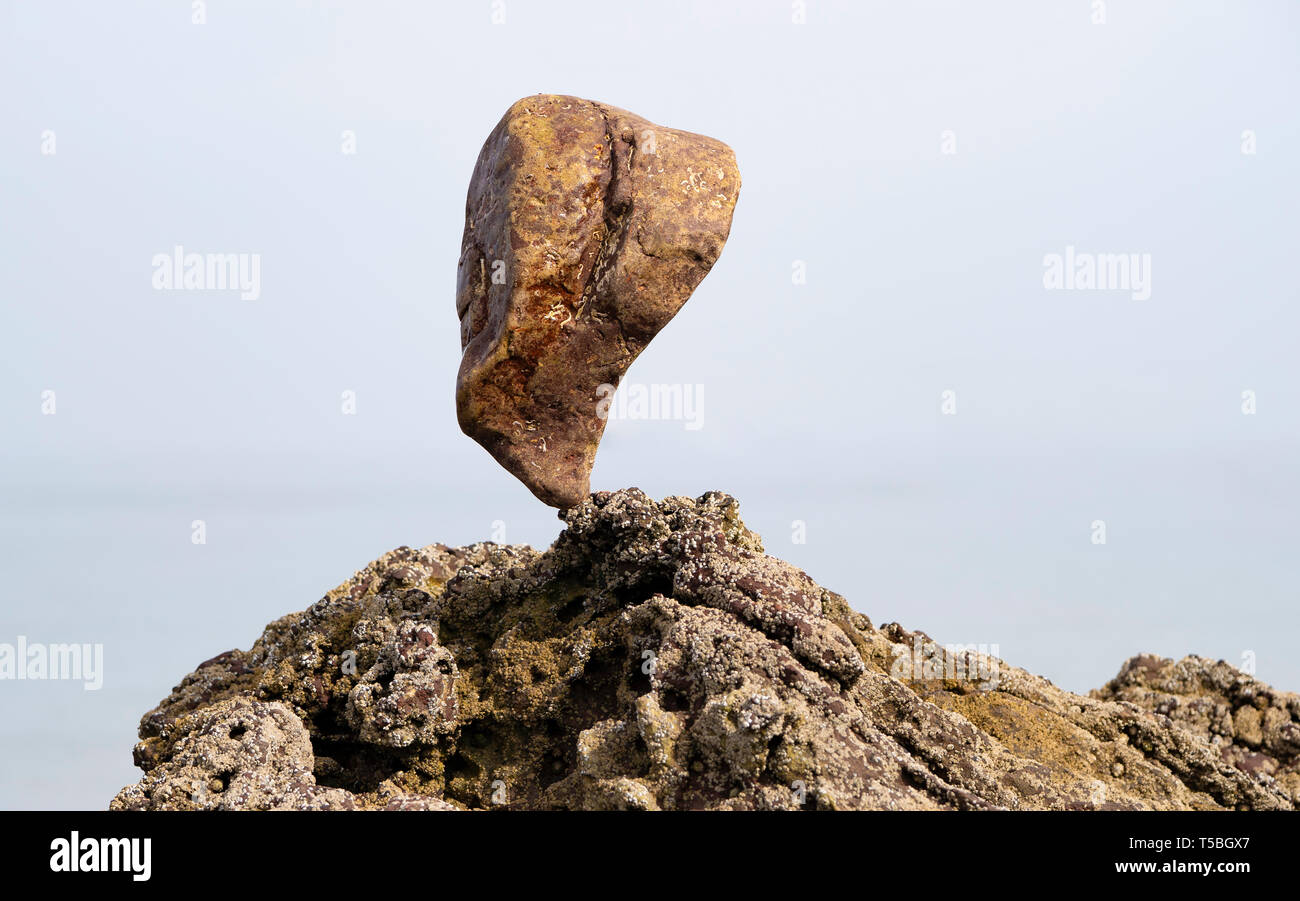 Mit einem großen Stein auf Felsen ausgeglichen Stockfoto