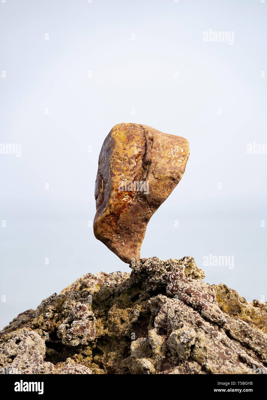 Mit einem großen Stein auf Felsen ausgeglichen Stockfoto