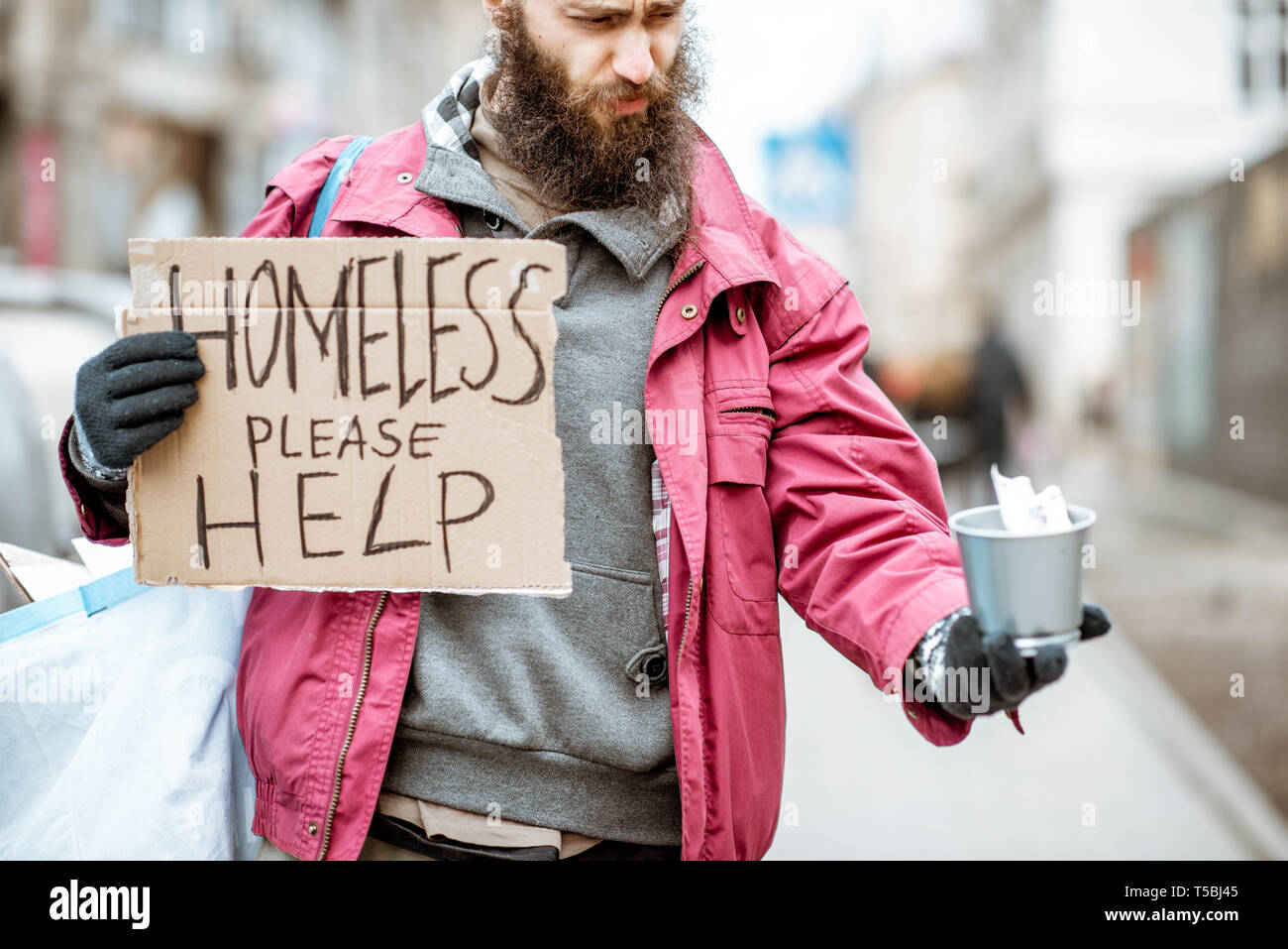 Porträt einer gedrückten obdachlosen Bettler mit Karton Betteln etwas Geld auf der Straße in der Stadt Stockfoto
