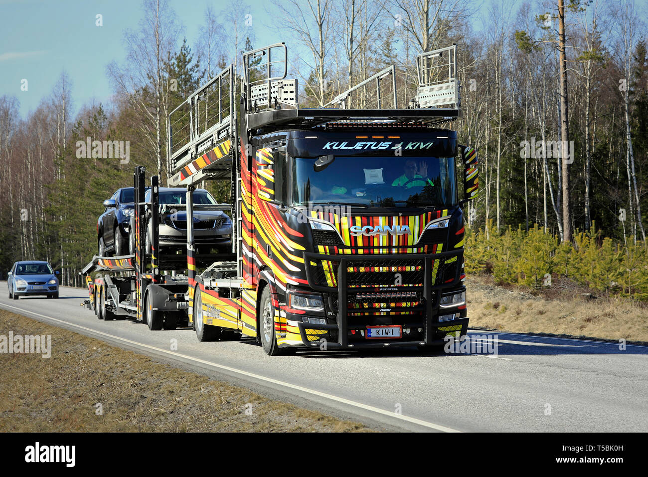 Tenhola, Finnland - 12 April 2019: einzigartiges Fahrzeug carrier Scania R 650 Der kuljetus J. Kivi hols Autos entlang der Landstraße an einem Tag des Frühlings. Stockfoto