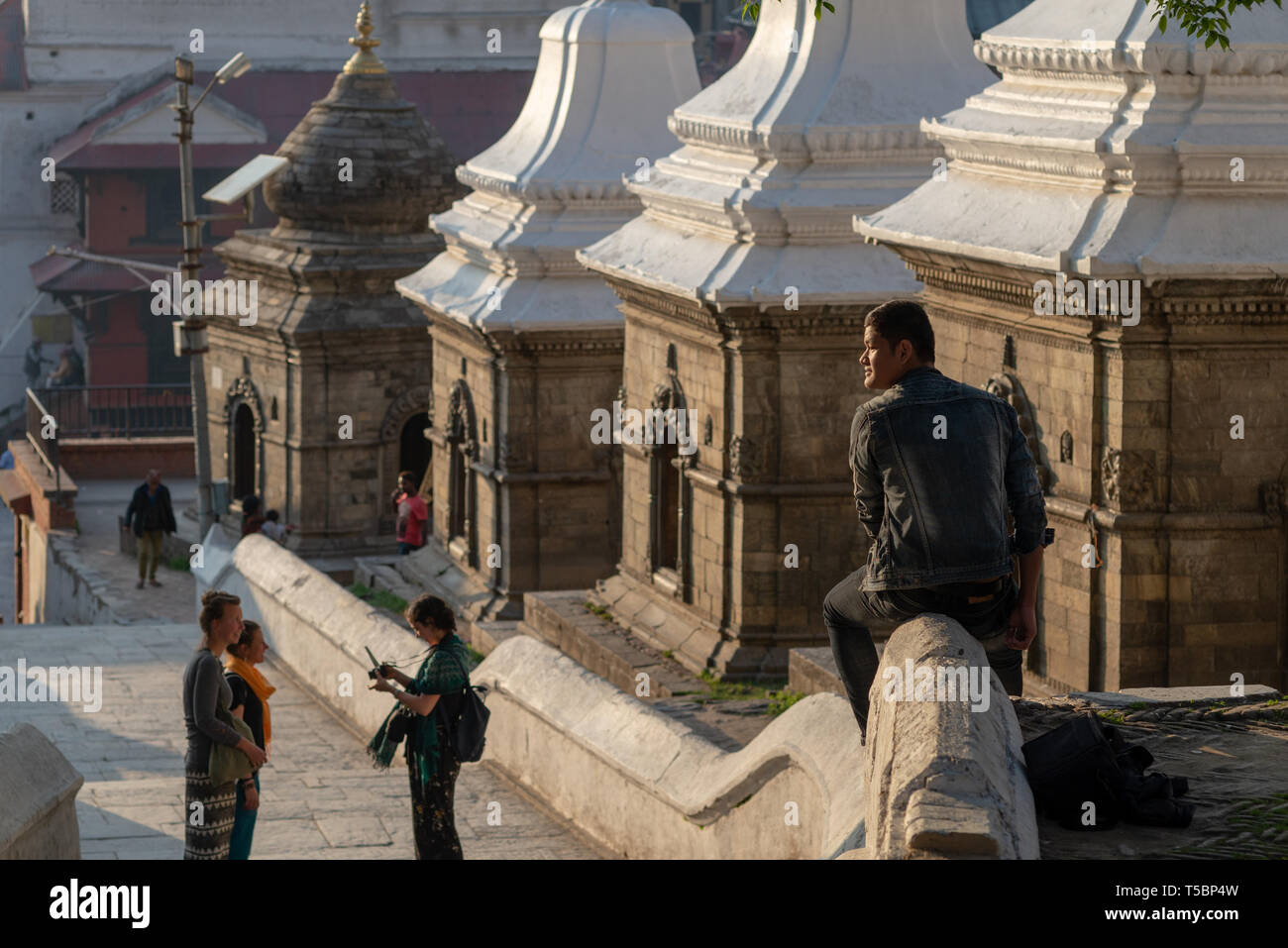 TILGANGA, Kathmandu, Nepal - April 2, 2019: Besucher und mehrere kleine Tempel schutz Shiva Lingams Stockfoto