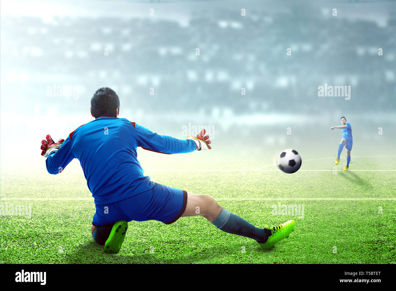 Asian Football Player Mann kicken den Ball auf das Ziel, die auf Fußball Feld am Stadion Stockfoto