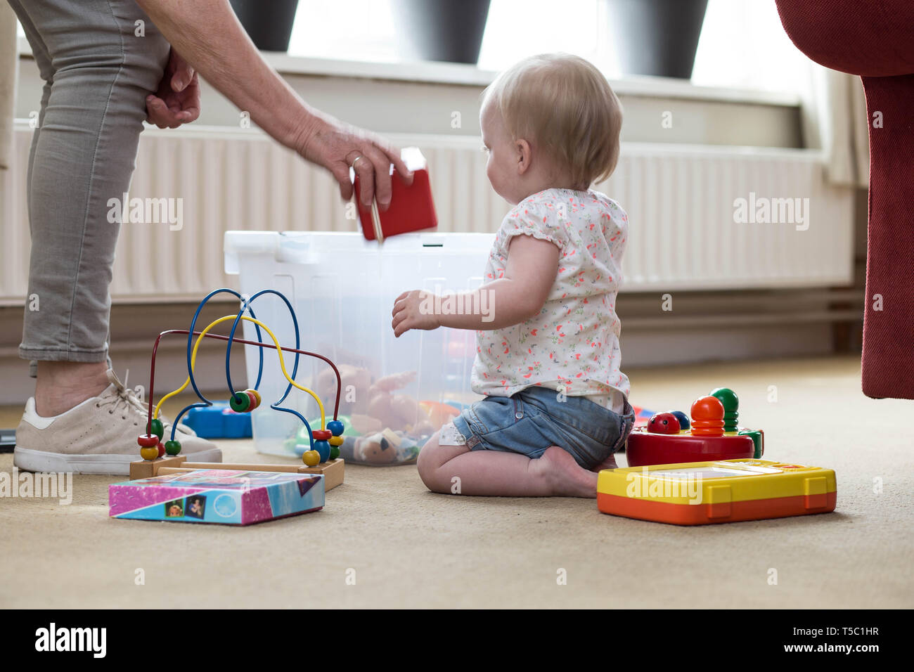 Oma und Kind mit Spielzeug auf dem Boden im Wohnzimmer Stockfoto