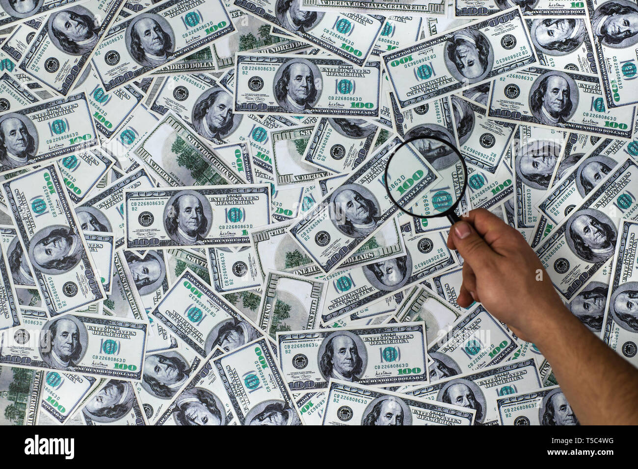 Mann mit Lupe auf die hundert amerikanische Dollar Hintergrund Stockfoto