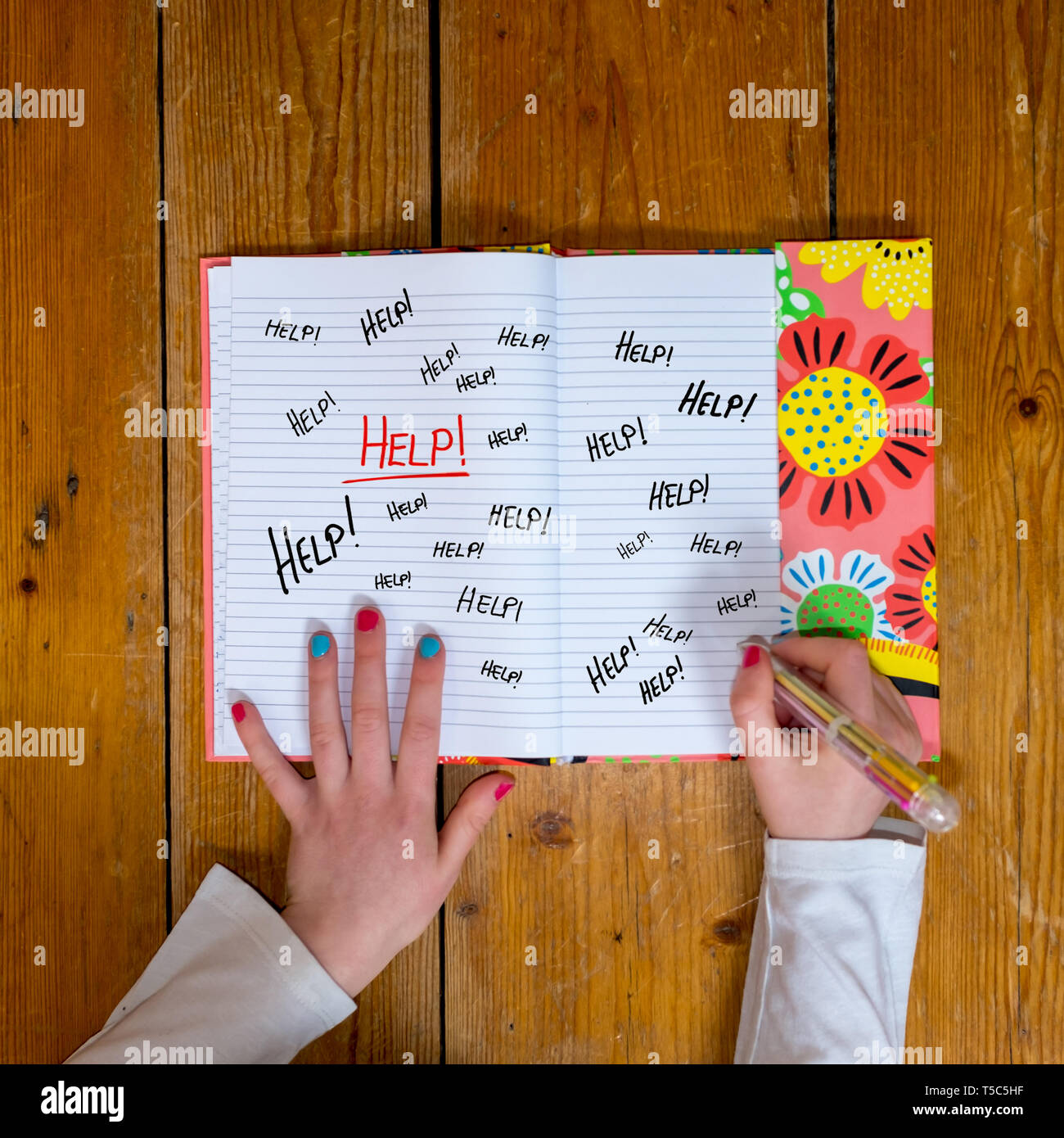 Junge Mädchen schreiben das Wort Hilfe viele Male in einem vintage Tagebuch Stockfoto