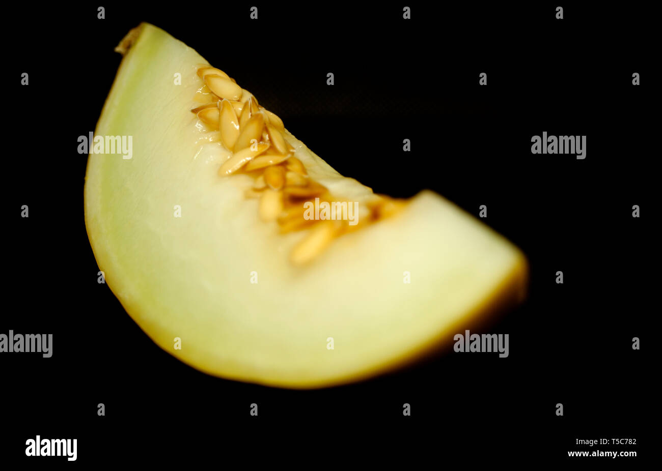 Honigmelone mit Körnern auf schwarzem Hintergrund Stockfoto