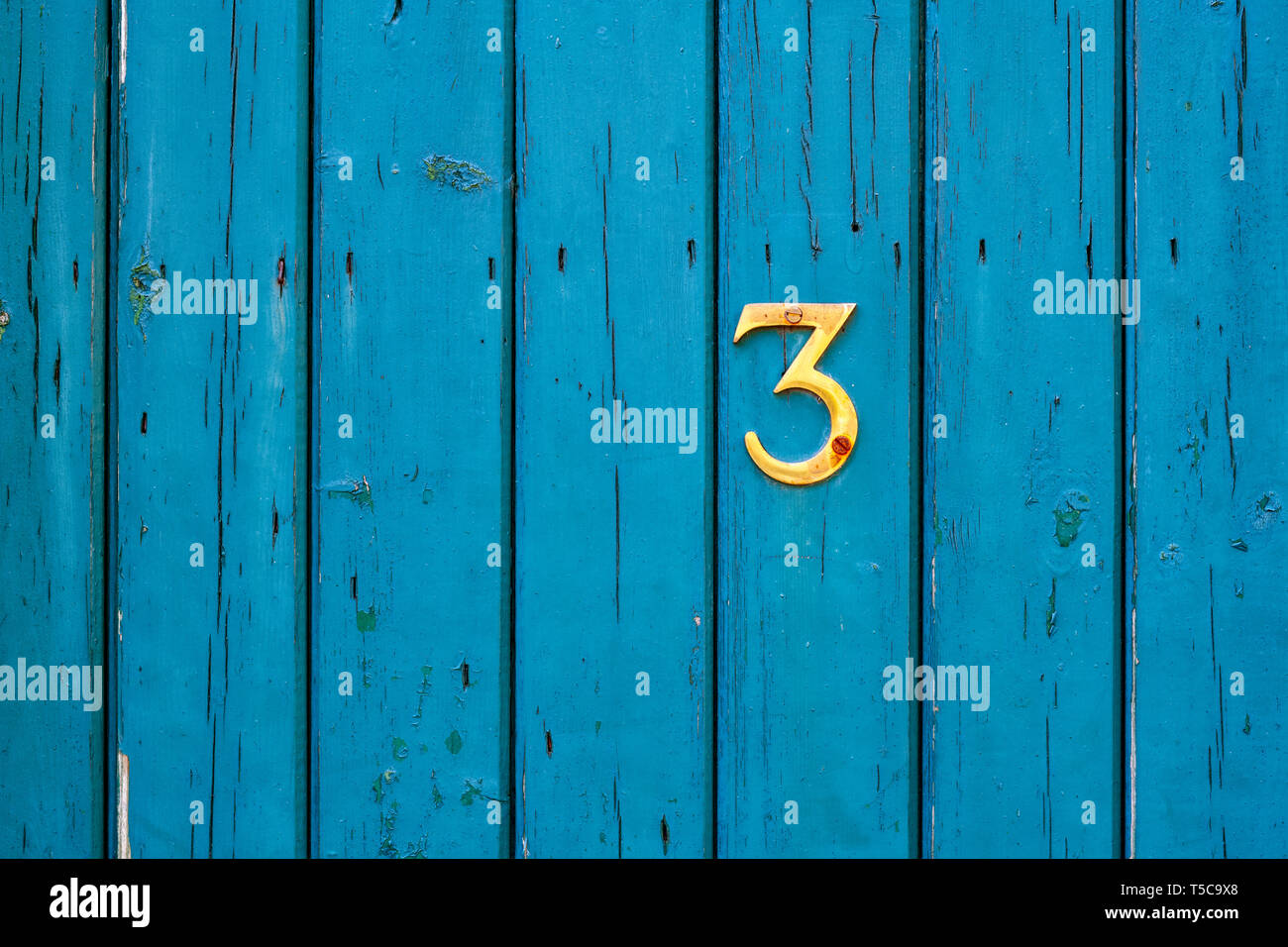 Messing Nummer 3 auf eine Krickente farbige hölzerne Gartentor. UK Stockfoto