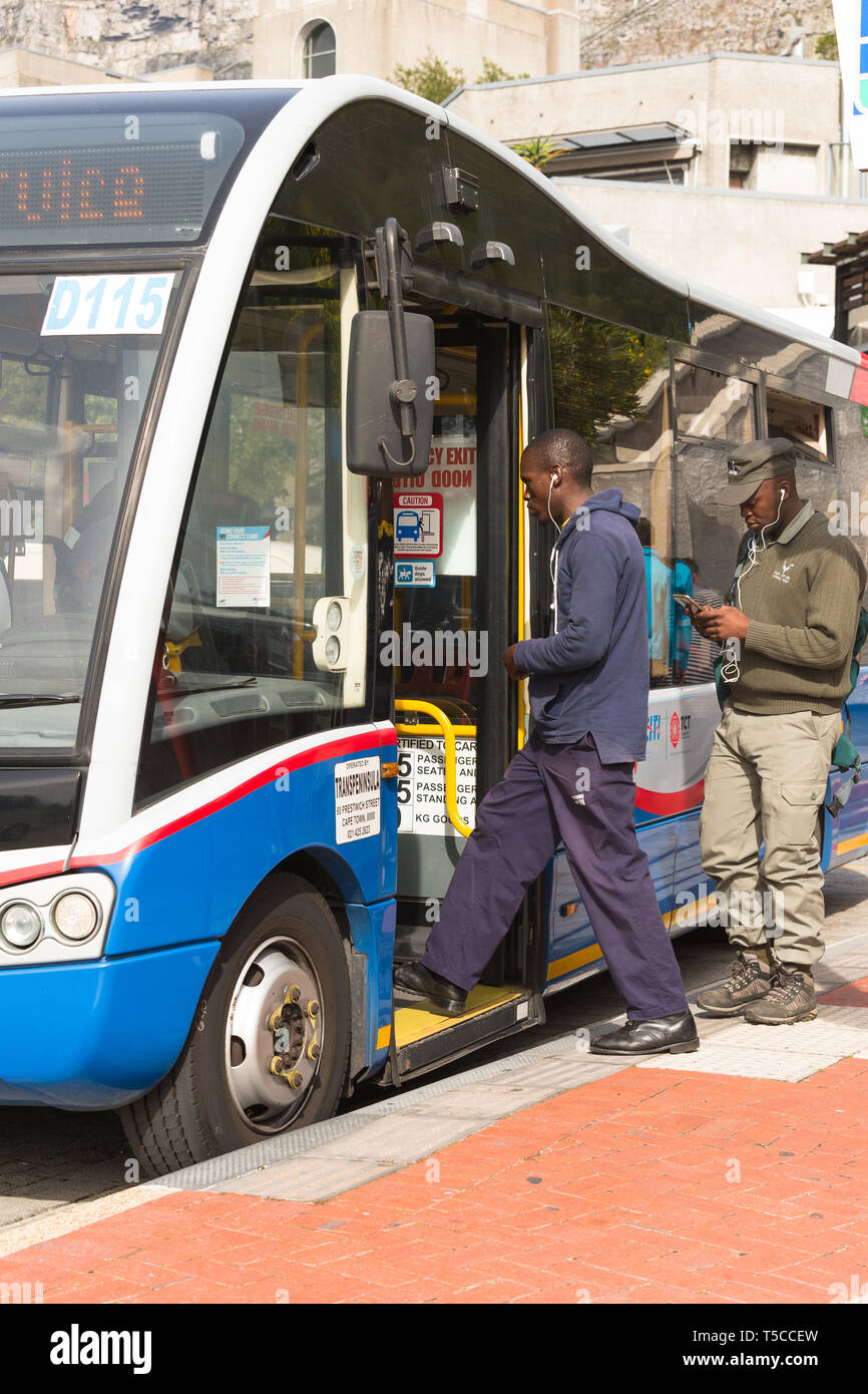 Menschen klettern oder auf oder an Bord eines stationären Meine Citi Bus an einer Bushaltestelle auf dem Tafelberg Kapstadt Südafrika am Ende eines Tages Stockfoto