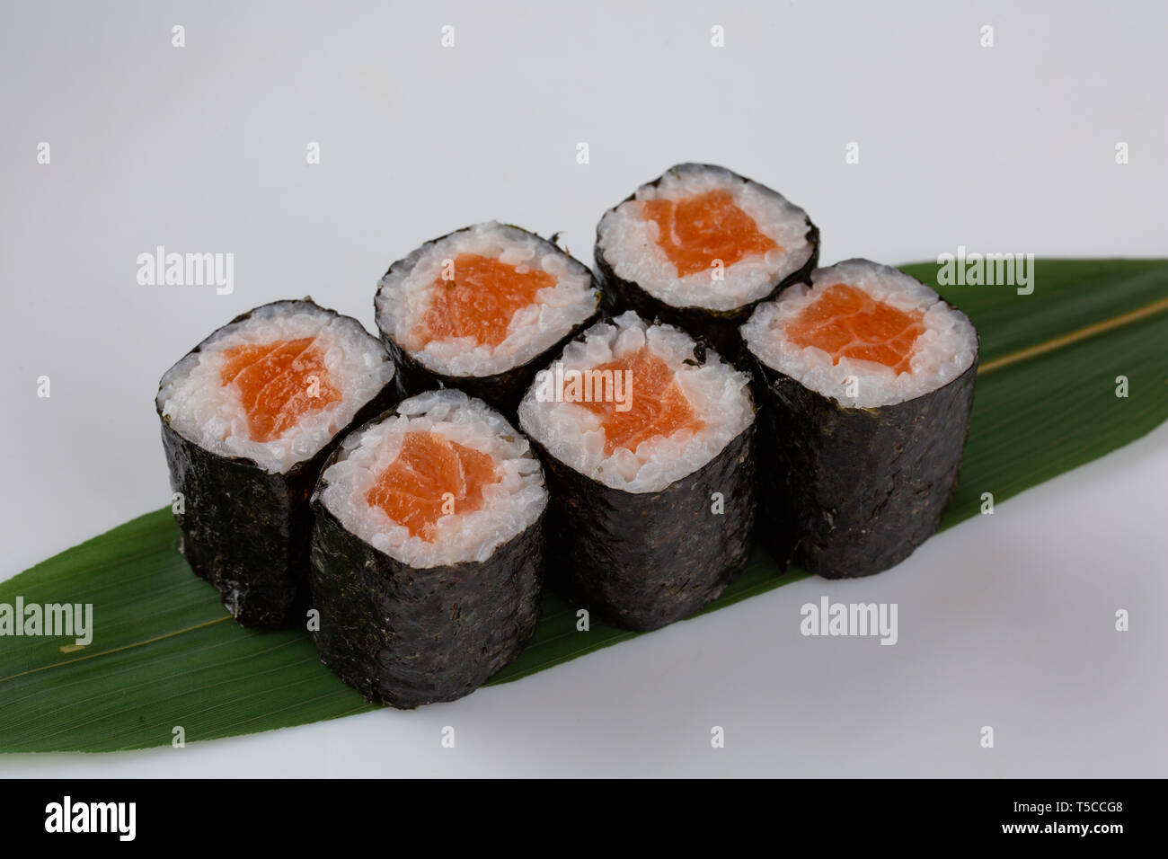 Sake maki japanisches Sushi Brötchen mit Lachs auf bananenblatt auf weißem  Hintergrund Stockfotografie - Alamy