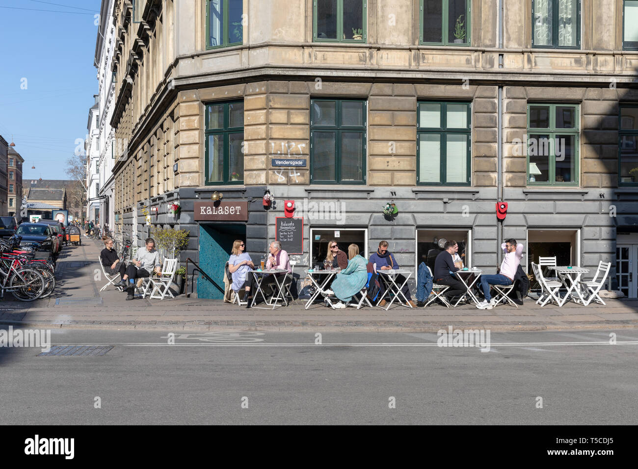 Menschen in Vendersgade/Nansensgade, Kopenhagen, Dänemark outside cafe Kalaset sitzen, im frühen Frühling Sonnenschein Stockfoto