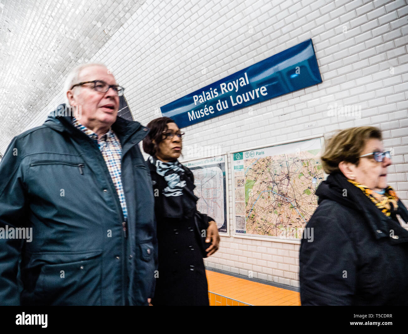 Paris, Frankreich, 19.März 2019: Senioren und Erwachsene Gruppe der Pendler Menschen zu Fuß innerhalb von Paris im Palais Royal Musée du Louvre Museum mit Karte von Paris auf den Fliesen weiße Wand Stockfoto