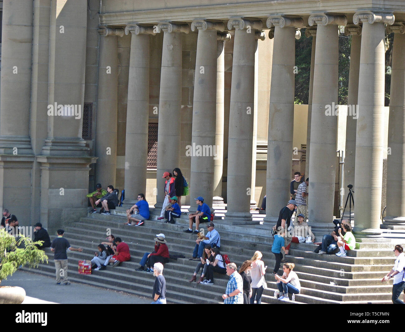 Eine Masse von Menschen sitzen auf den Stufen eines Gebäudes in San Francisco. Stockfoto