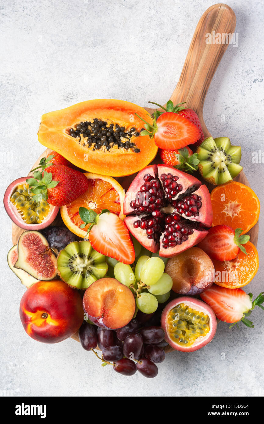 Leckere Obstplatte Granatapfel papaya Orangen Leidenschaft Früchte auf Holzbrett auf weissem, Ansicht von oben, selektiver Fokus Stockfoto