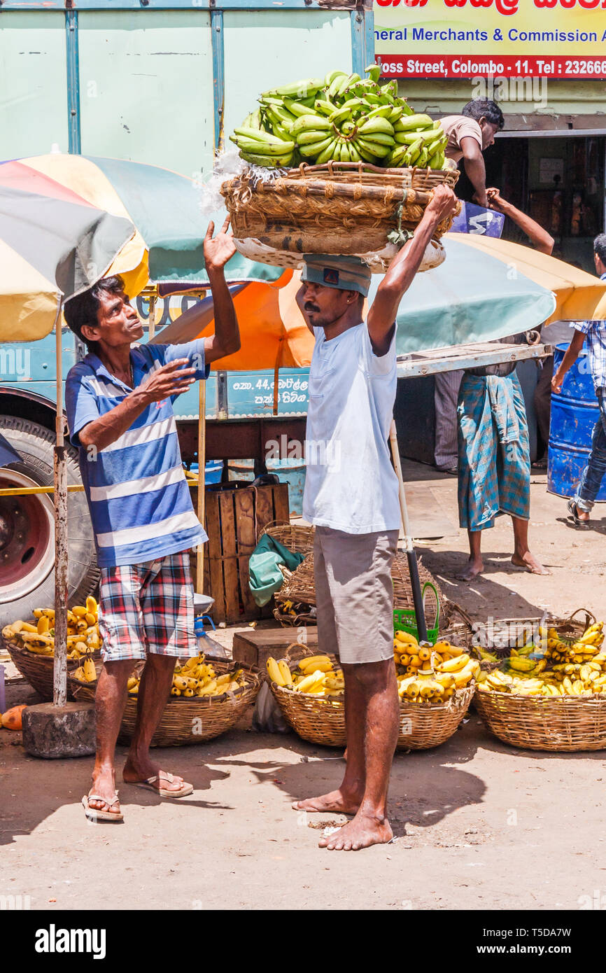 Colombo, Sri Lanka - 16. März 2011: Mann, der Bananen in einem Korb auf dem Kopf in den Pettah Bezirk. Dies ist der Handel und die Fläche des Stockfoto