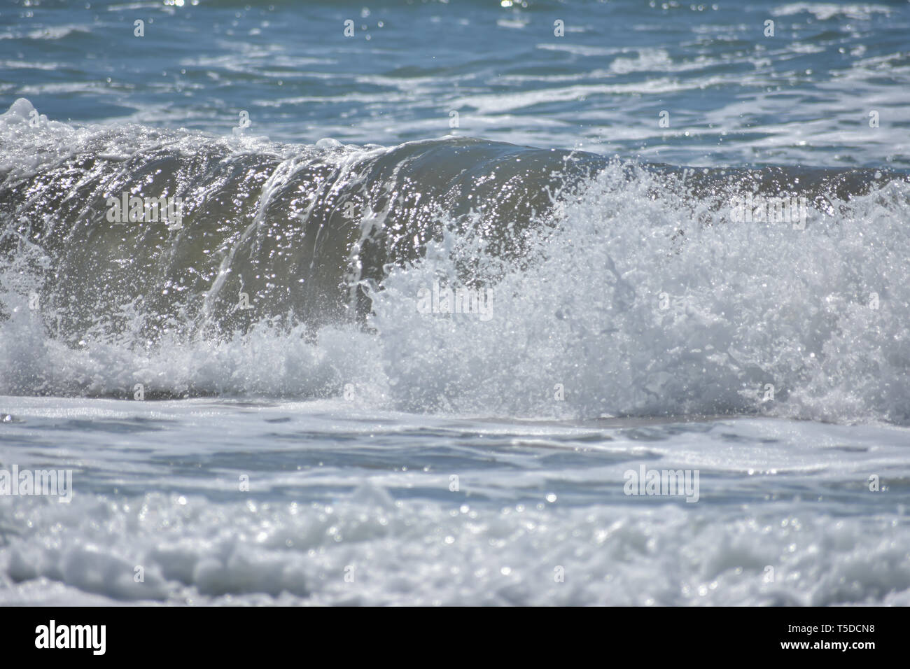 Rolling Ocean Wave Absturz in die Ufer von einem Strand ein Spray von Sea Foam. Stockfoto