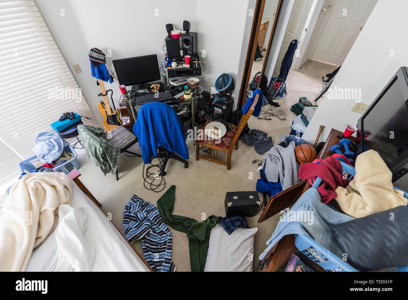 Sehr chaotisch, Überladen, das Schlafzimmer der Teenager mit Stapel von Kleidung, Elektronik, Musik und Sport. Stockfoto
