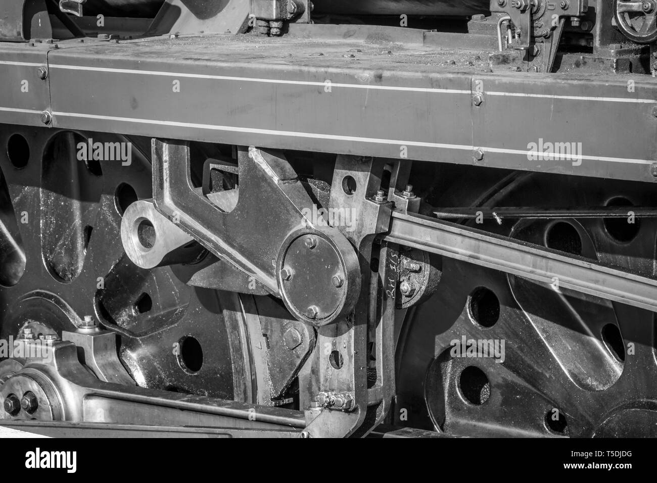 Schwarze und weiße Nahaufnahme von Vintage UK Dampflok Räder. Seitenansicht der Dampfzug Antriebsräder mit Anschluss Koppelstange. Stockfoto