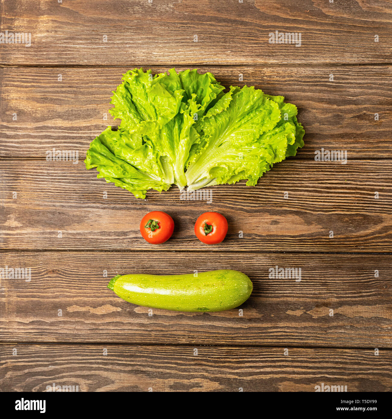 Spass Lustiges Gesicht Mit Frischem Gemuse Tomaten Zucchini Salat Auf Einem Holzernen Hintergrund Gesunde Ernahrung Vegetarismus Stockfotografie Alamy