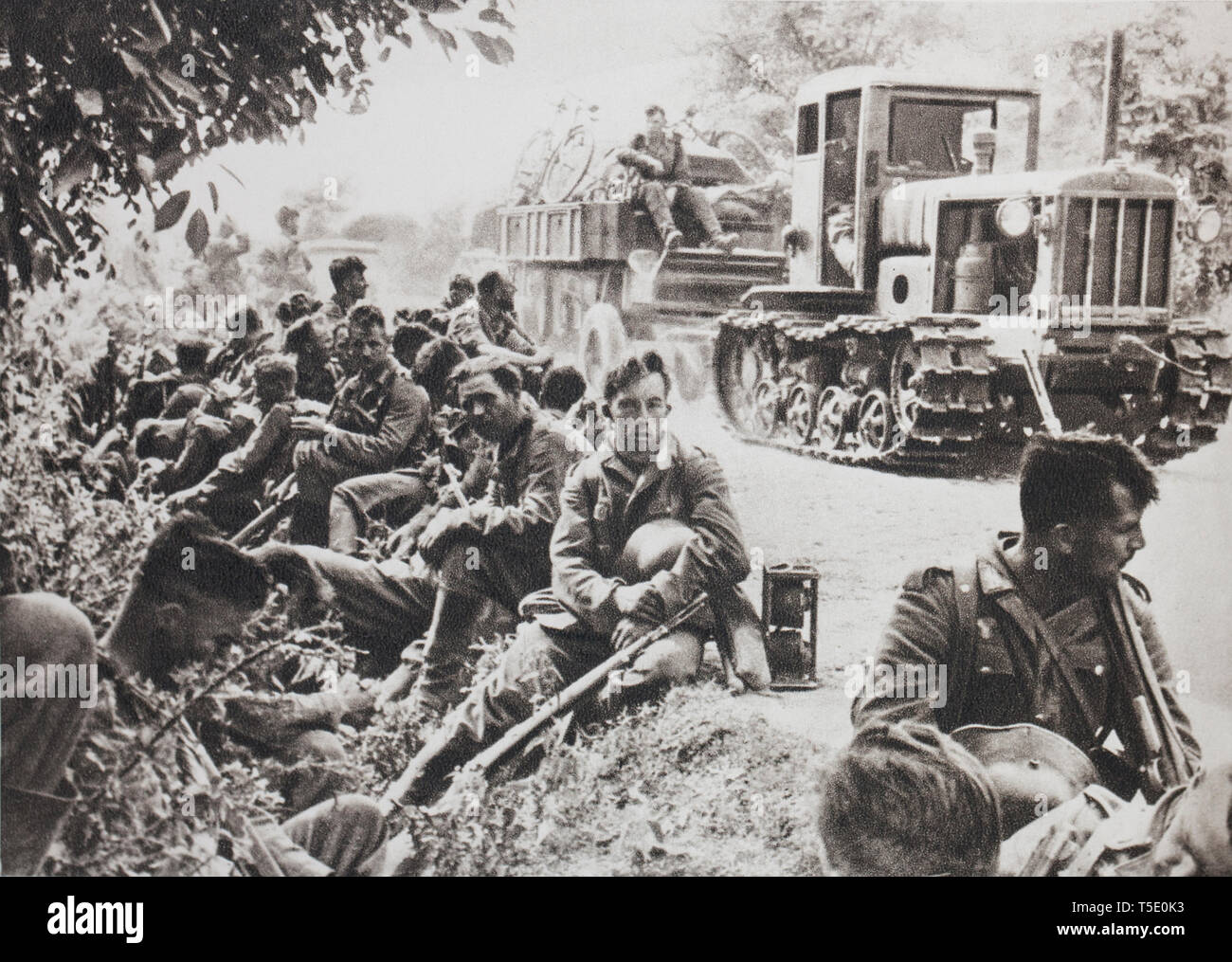 Deutsche Infanterie in Ruhe auf einer Straße aus der Ukraine (1941). Es kommt vor, dass es nur ein Land gnadenlos von den Russen beschädigt. Stockfoto