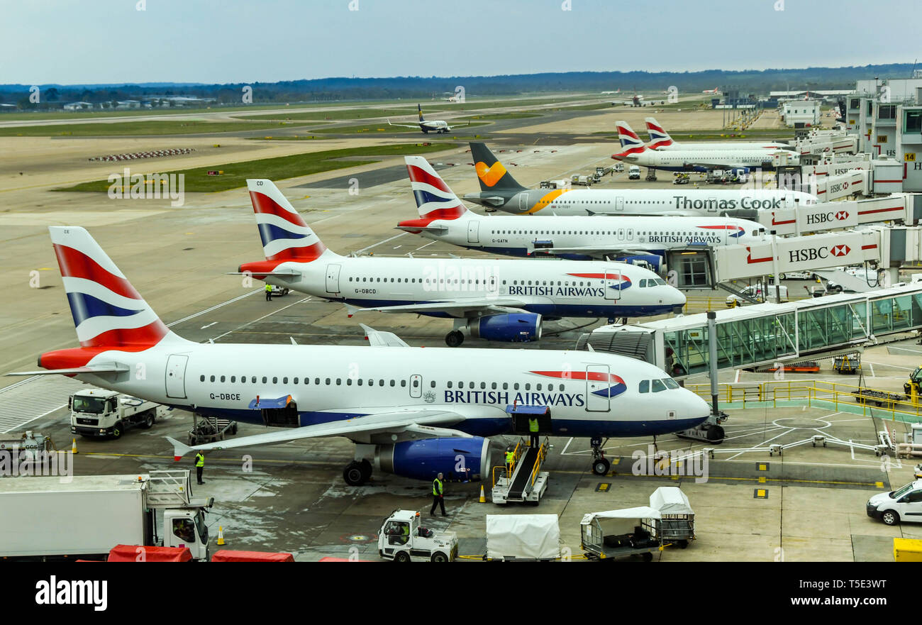 Der Flughafen London Gatwick, ENGLAND - April 2019: British Airways Jets und Thomas Cook einen Jet bei South Terminal, Gatwick Airport Stockfoto