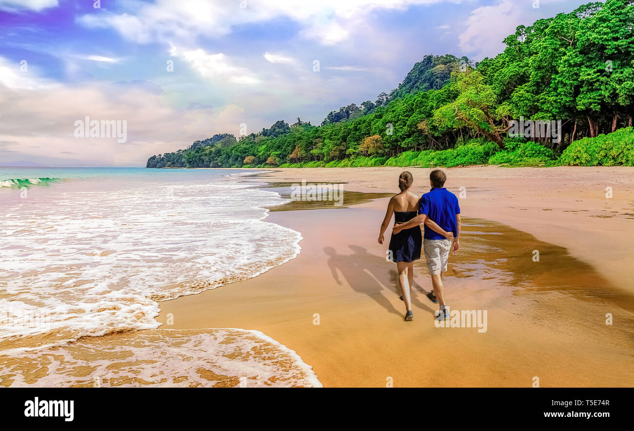 Paare auf Hochzeitsreise genießen Spaziergang entlang der malerischen Havelock Island Sea Beach Andaman, Indien bei Sonnenuntergang Stockfoto