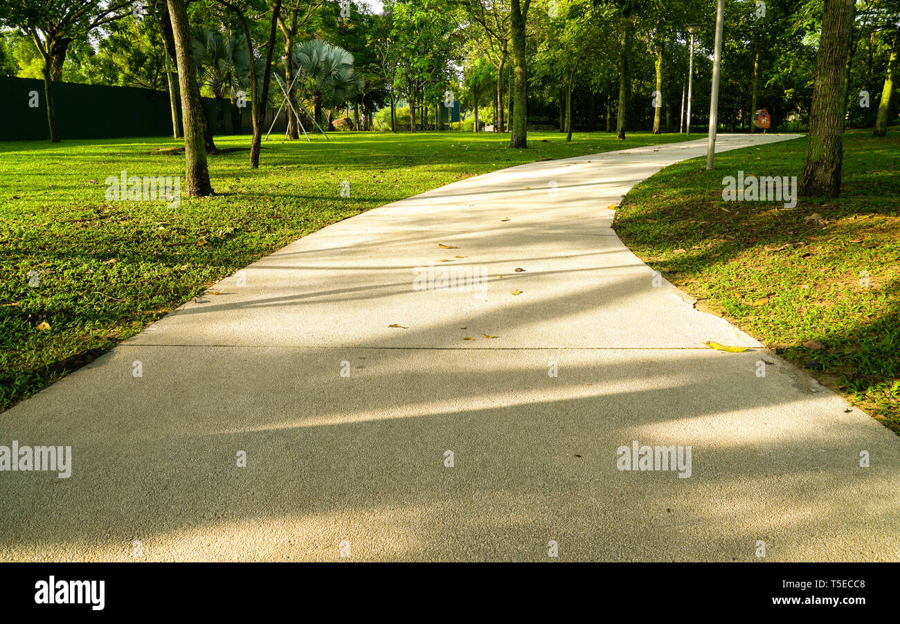 Kiesweg in einem Park mit grünen Wiesen und Bäume um Stockfoto