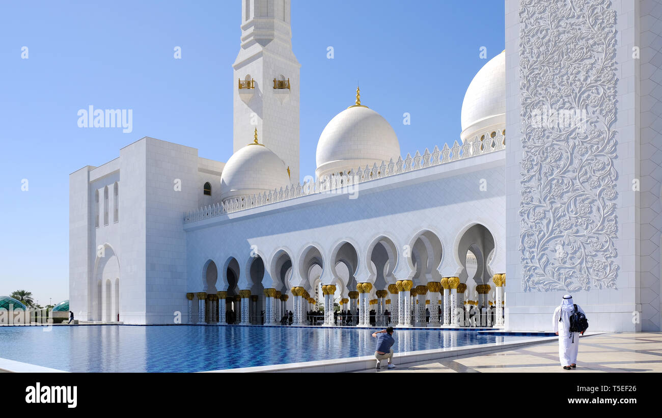 Abu Dhabi, Vereinigte Arabische Emirate, 7. Februar 2019: ruhige Szene, berühmten weißen Marmor Sheikh Zayed Moschee in Abu Dhabi. Zwei Männer sind Kreuzung t Stockfoto