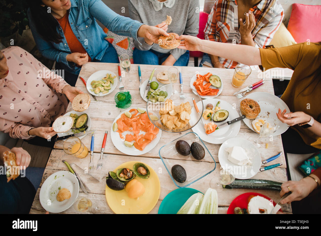 Hohe Betrachtungswinkel und einer kleinen Gruppe von weiblichen Freunden ein gesundes Mittagessen in einem Wintergarten an einem Wochenende vorbereiten. Stockfoto