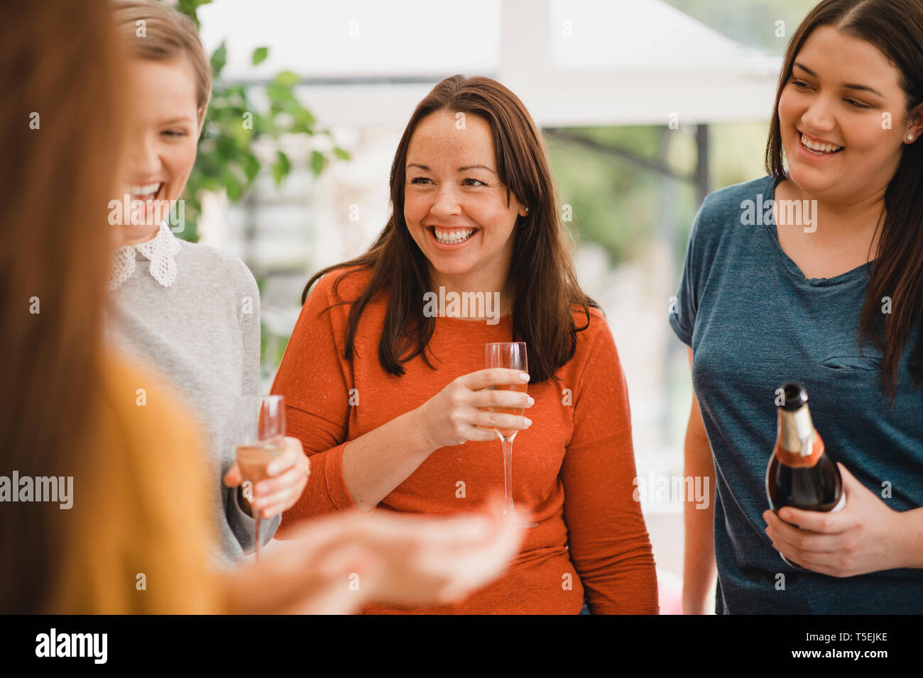 Kleine Gruppe von weiblichen Freunde feiern eine Party. Sie werden mit einem Glas Champagner, Lachen und Lächeln. Stockfoto