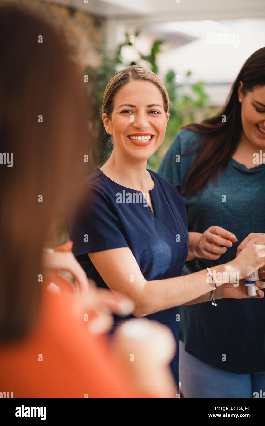 Blick über die Schulter eines Schönheit Produkt Vertriebsmitarbeiter Kunden zeigen. Sie ist damit eine nicht erkennbare Person eine Schönheit pr Stockfoto