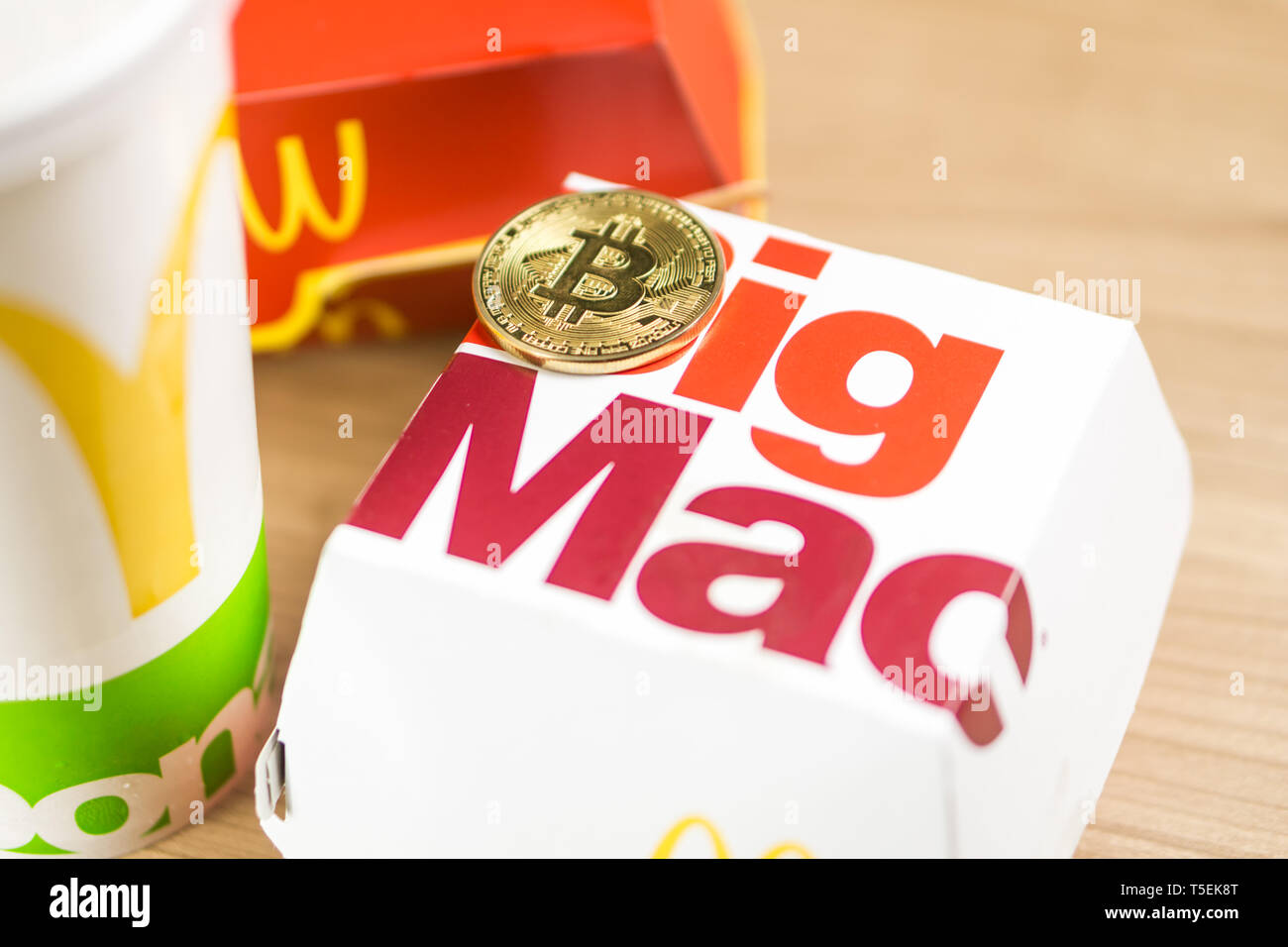 Ljubljana, Slowenien - 27 Dezember, 2018: Big Mac Box mit McDonald's Logo auf Tabelle im McDonald's Restaurant mit Bitcoin Münzen neben Stockfoto
