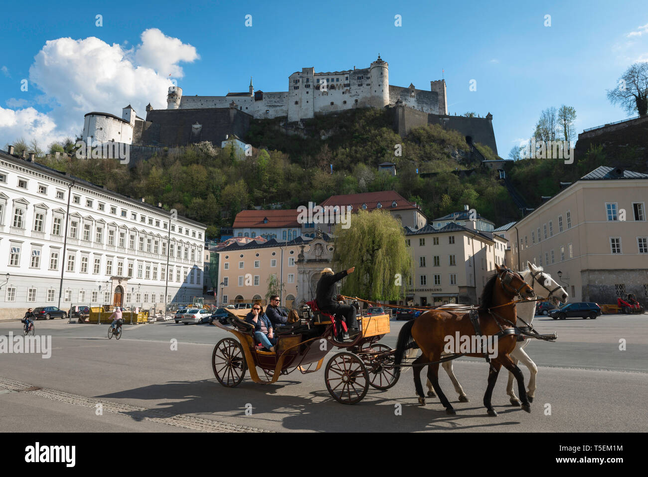 Stadt Salzburg Österreich, Blick auf eine Pferdekutsche durch Kapitelplatz mit Blick auf die Hügel Burg (Festung Hohensalzburg), Salzburg. Stockfoto
