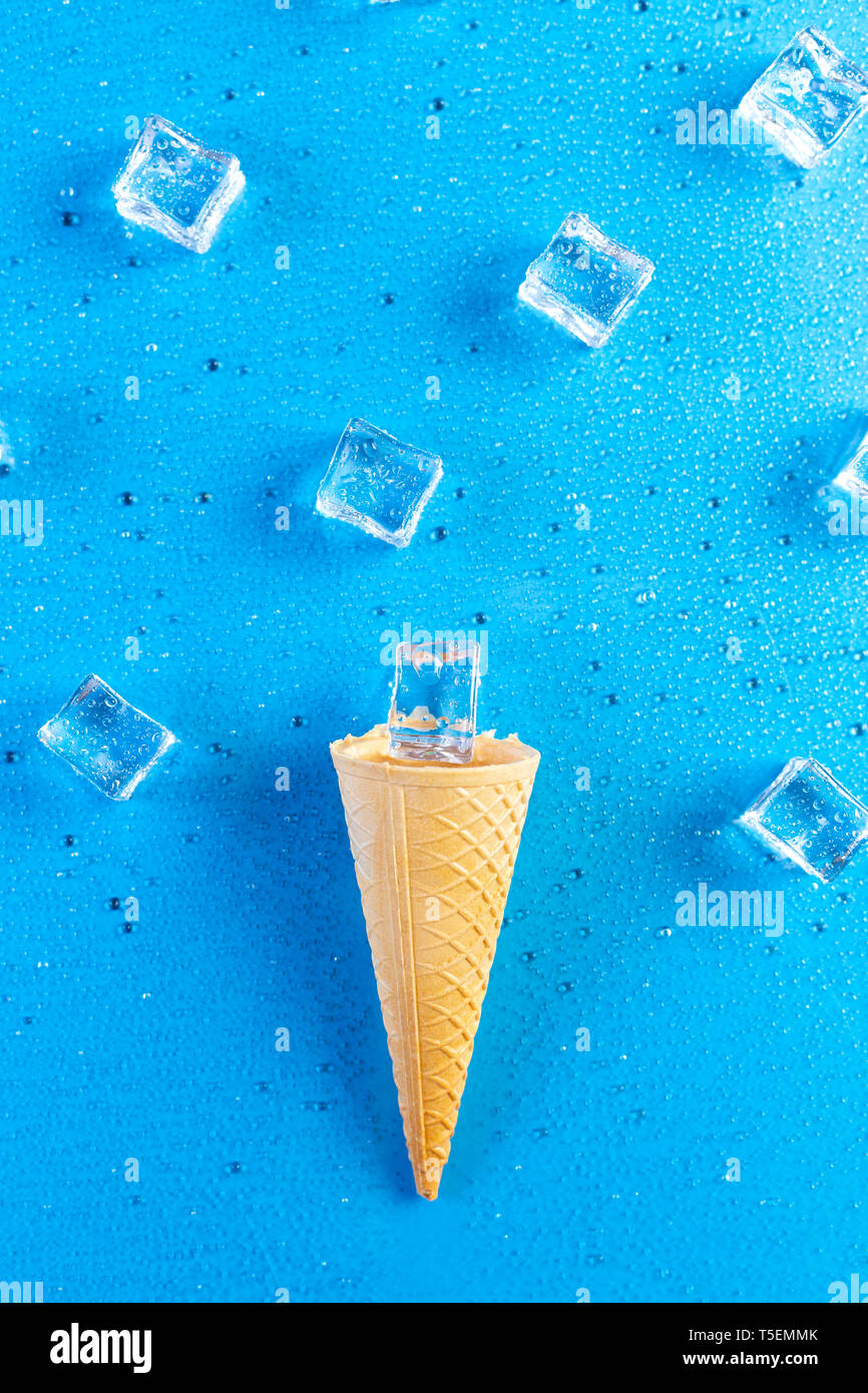 Eis mit Eiswürfeln auf blauem Hintergrund geschmolzen Stockfoto