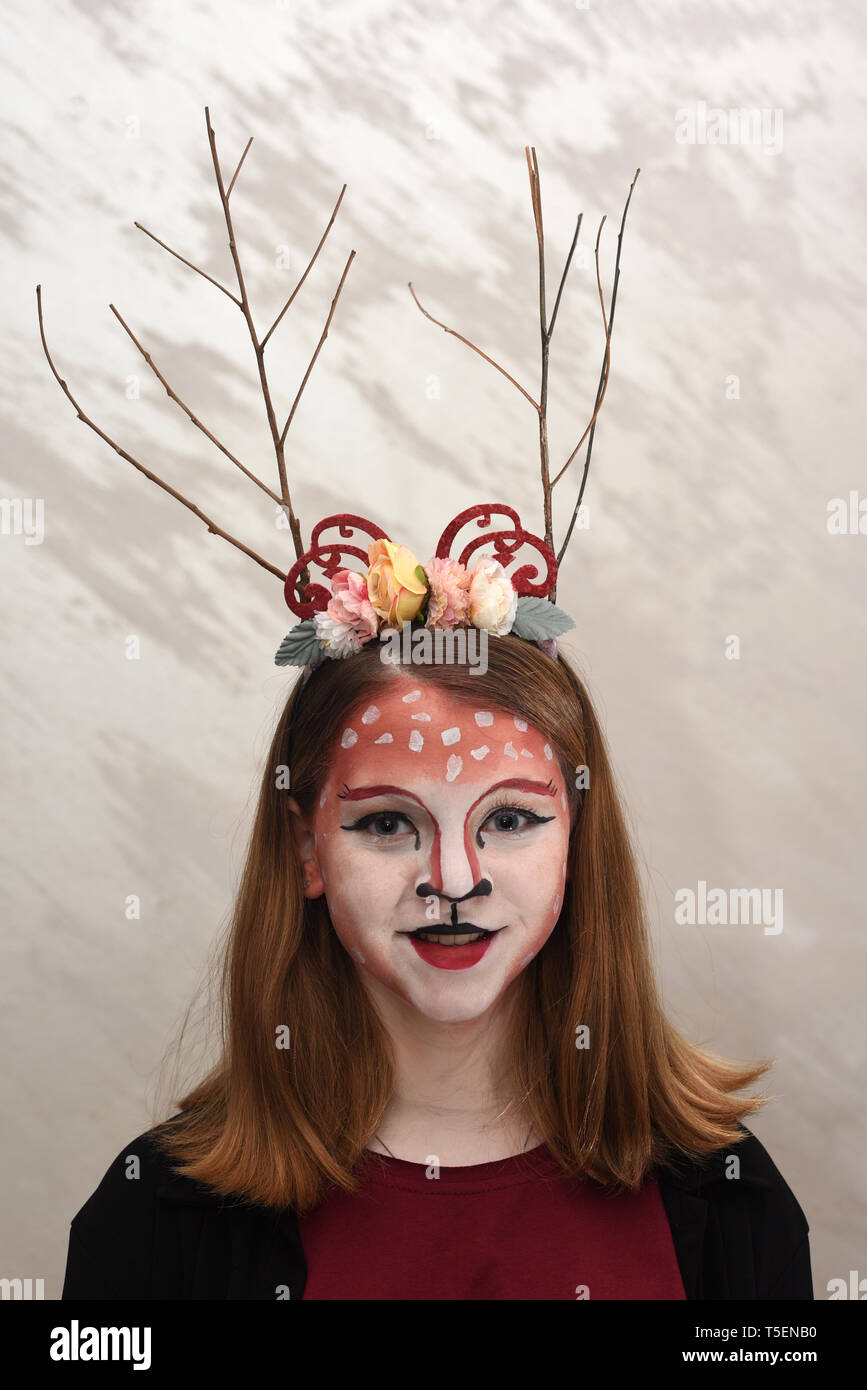 Junge jugendlich Mädchen mit Body Paint und Kostüm gekleidet wie ein Wald Märchen bereit für eine Halloween Party Stockfoto