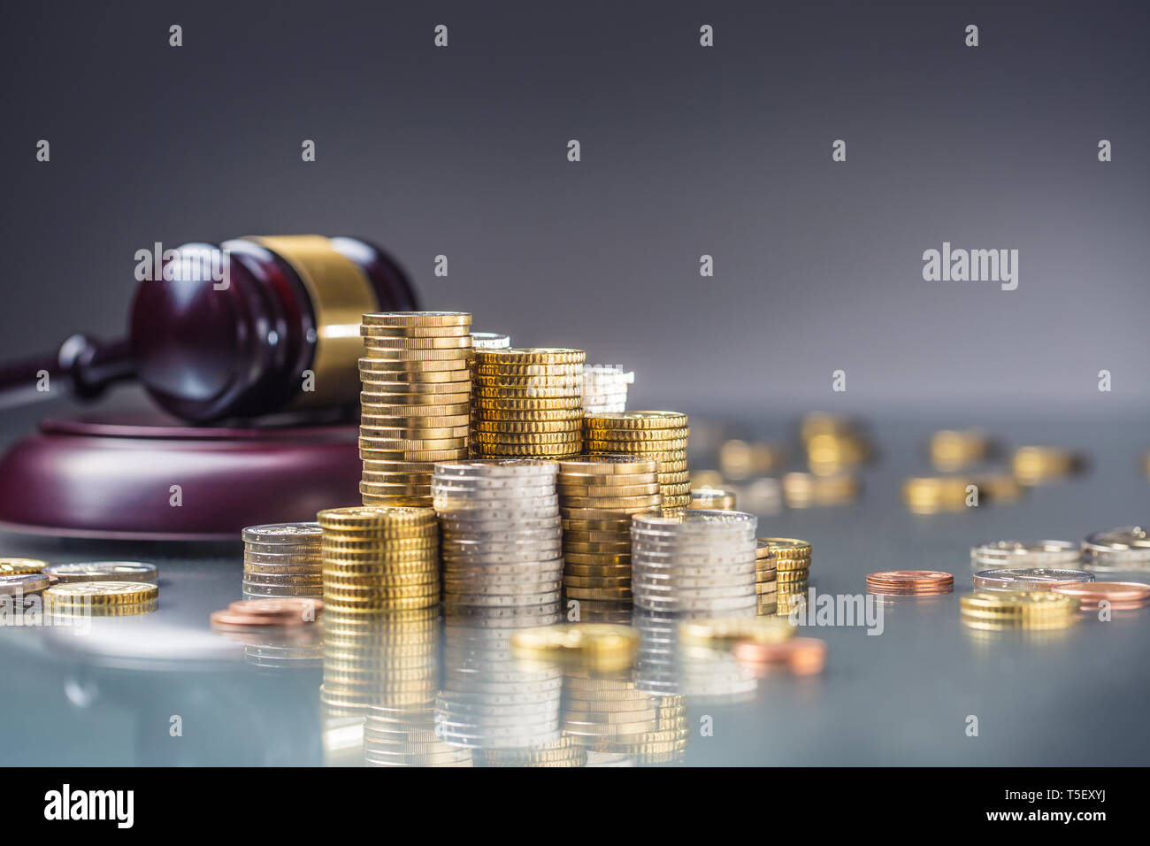 Türme mit Euro-Münzen und Gerechtigkeit Hammer im Hintergrund. Stockfoto