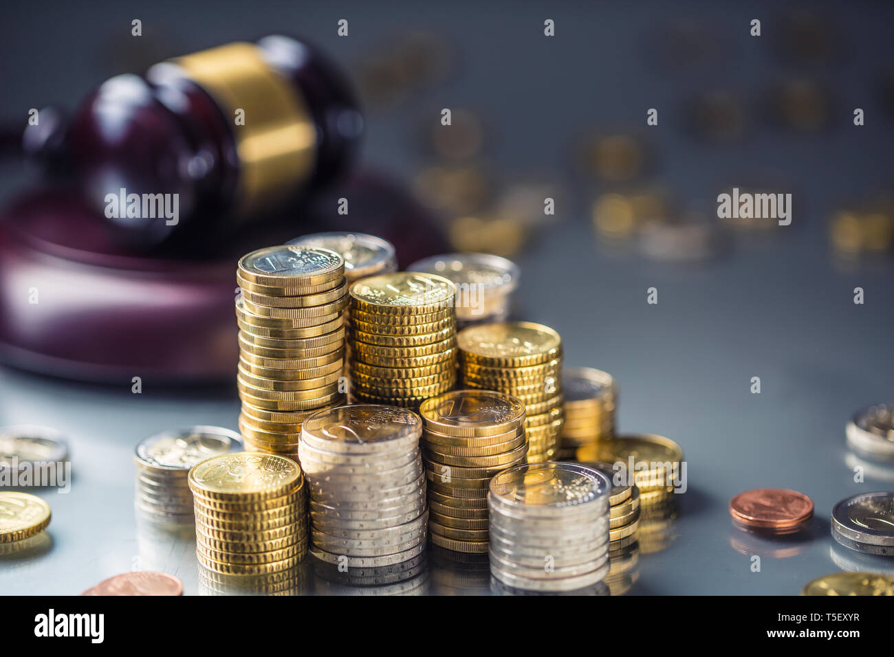 Türme mit Euro-Münzen und Gerechtigkeit Hammer im Hintergrund. Stockfoto