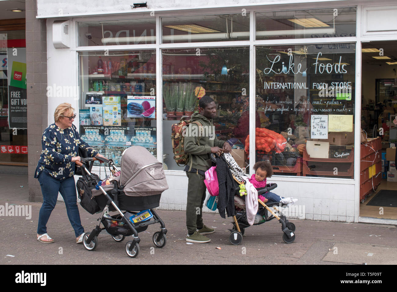 Multiethnische ArbeiterInnen, weiße Frau, schwarzer Brite mit Kindern im Kinderwagen, die in Dartford Kent 2019 2010s UK HOMER SYKES einkaufen gehen Stockfoto