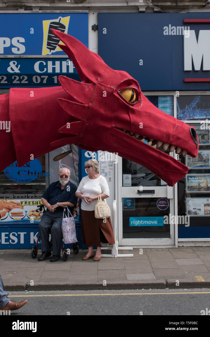 Dragon UK, St. Georges Day eine Parade am 23. April 2019, ein einheimisches Paar stoppt den Einkauf, um die festliche Prozession durch Dartford Kent, England, zu beobachten, HOMER SYKES der 2010er Jahre Stockfoto