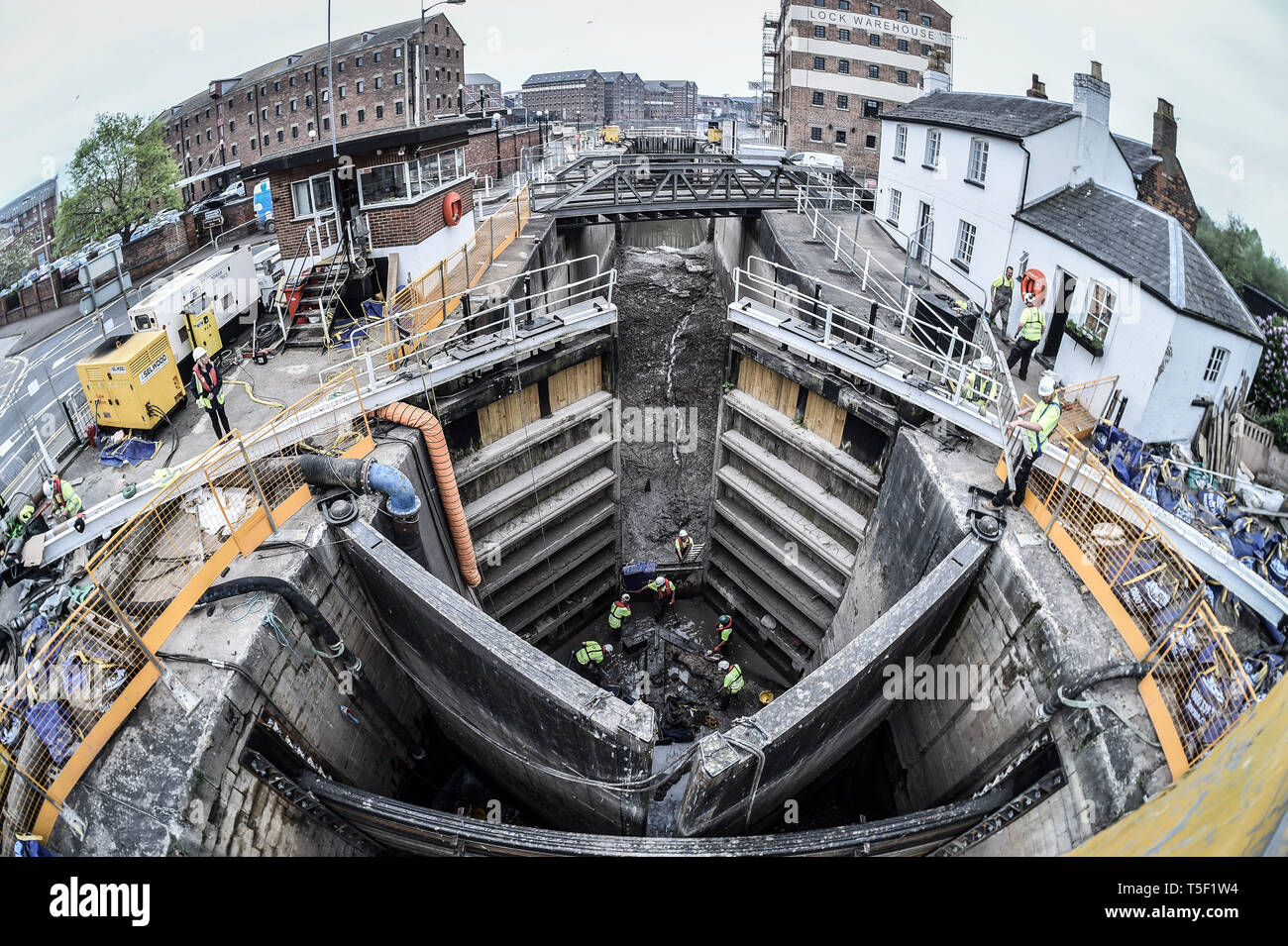 Ingenieure von der Canal and River Vertrauen ein Leck Reparatur auf der Basis eines tiefen 200 Jahre alte, denkmalgeschützte Schloss in Gloucester, wo die Tidal River Severn Gloucester Docks in der Stadt trifft und eine speziell hergestellte Stahl Dam ist jetzt zurück halten den Fluss von Wasser, mit mehr als 100 Tonnen des angesammelten Schlick aus dem Bereich der Beschädigung des Schlosses entfernt wird, so dass das Team Reparaturen durchführen kann. Stockfoto