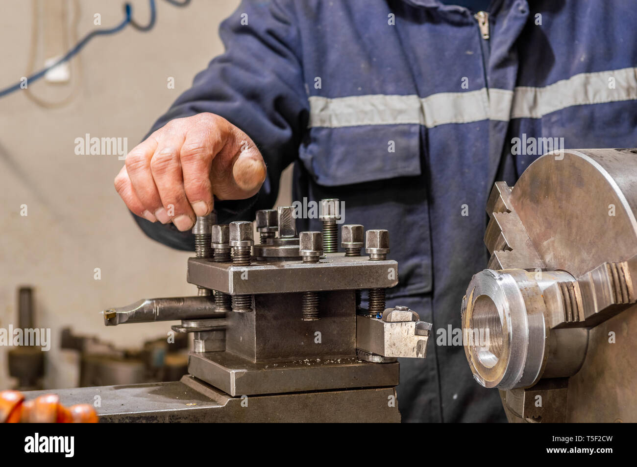 Blue-collar-Maschinenbediener arbeiten mit Drehbank Maschine in einer Fabrik. Stockfoto