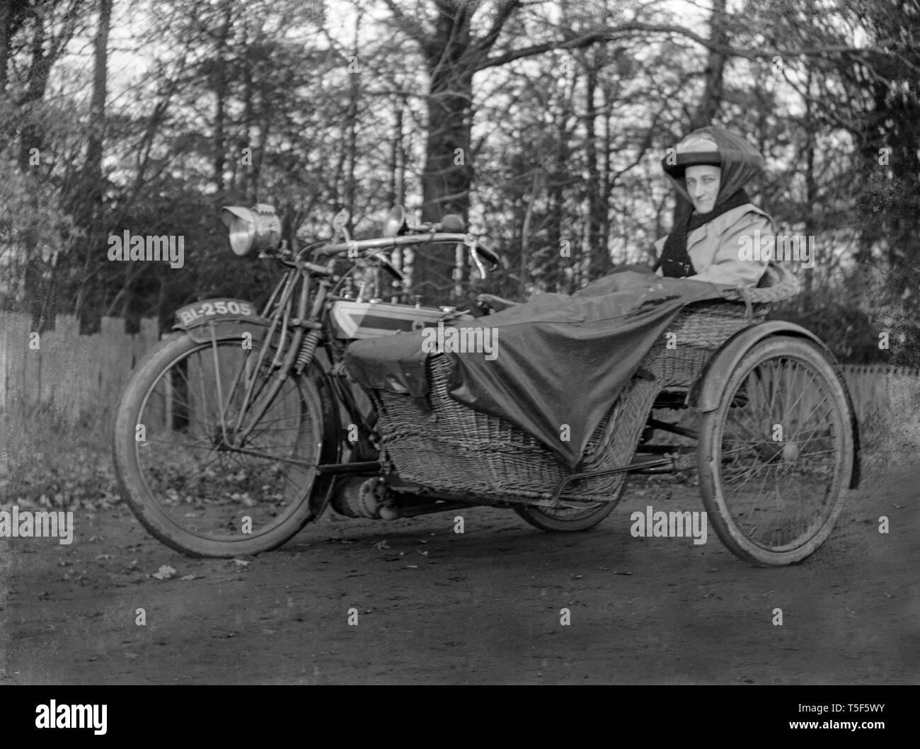 Ein Foto einer Dame im Auto eines Vintage Triumph Motorrad und Auto sitzen. Die Seite ist aus Rattan. Stockfoto
