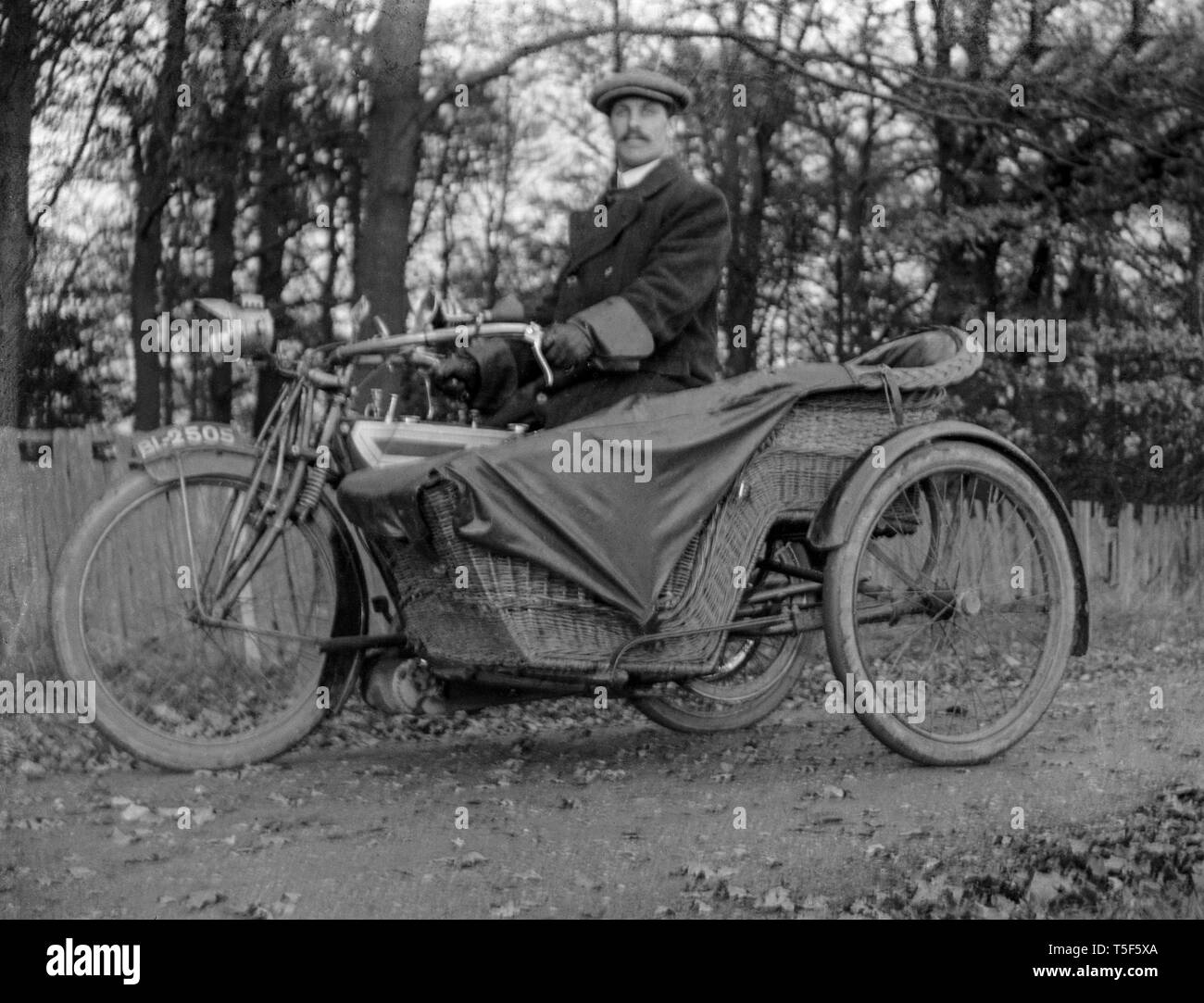 Ein Foto von einem Mann sitzt auf einem Oldtimer Triumph Motorrad und Beiwagen. Die Seite ist aus Rattan. Stockfoto