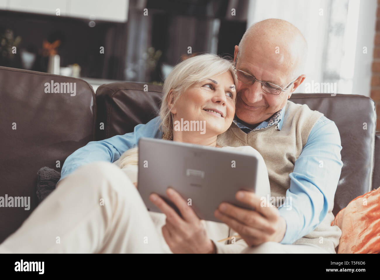 Senior Paar mit digitalen Tablette zu Hause. Großeltern mit Social Media. Stockfoto