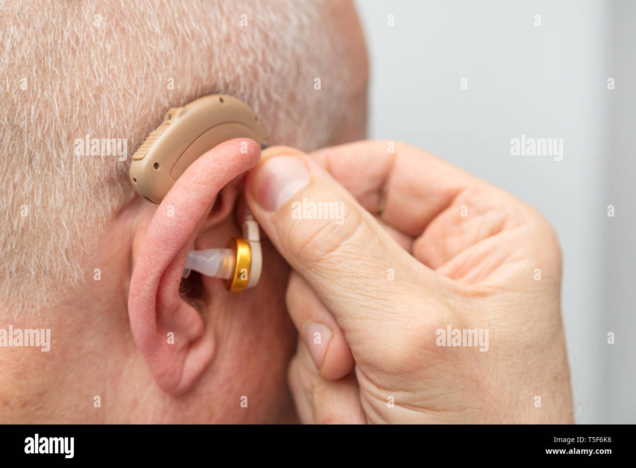 Hörgerät im Ohr des gealterten alten Mann. Senior mit modernen Hörgeräten Stockfoto